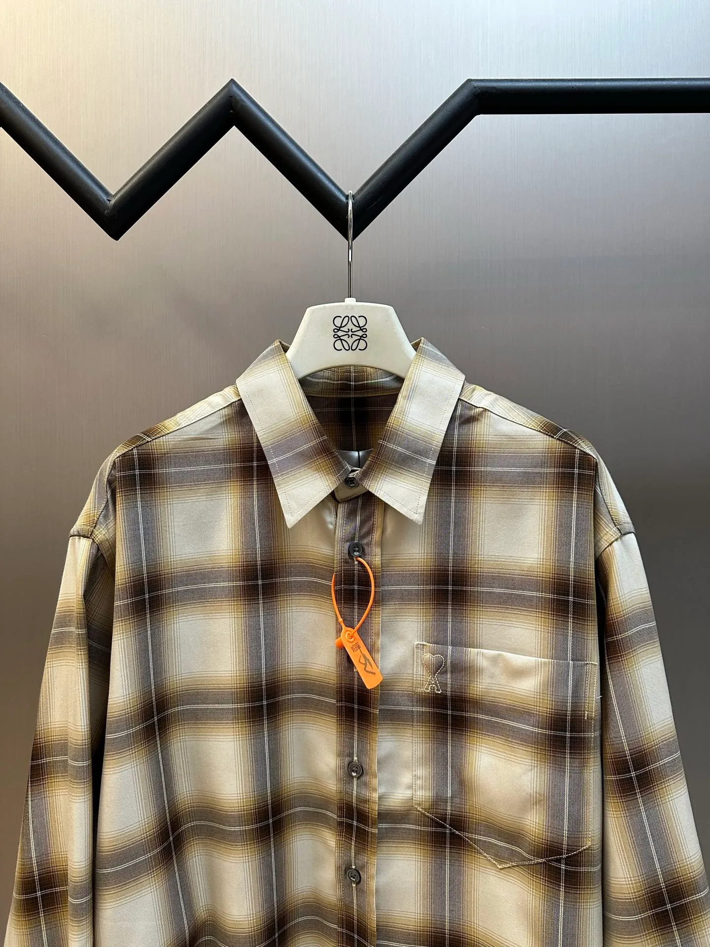 Ami Paris embroidered plaid shirt is a custom-made cloud-like Lyocell plaid Canvas, with warm brown and Cream White gradients intertwined into a mist plaid. The small chest pocket is embroidered with AMI's iconic small love heart, and the brand logo is hidden with fine stitching. It is low-key but powerful, with an undercurrent of light luxury style in the blank space, which perfectly interprets the delicate balance between French relaxation and old money style. Using imported machine embroidery technology, advanced computer control systems and precision mechanical components, Ami love embroidery operations are realized. The infrared positioning cutting machine uses an infrared transmitter and an infrared receiver to achieve precise positioning of materials. The accuracy can reach the micron level, thereby meeting the effect of high-precision cutting of plaid and strip alignment. size:38.39.40.41